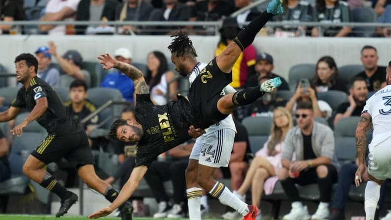 Jul 8, 2022; Los Angeles, California, USA; LAFC midfielder Ryan Hollingshead (24) is upended by LA Galaxy forward Raheem Edwards (44) in the first half at Banc of California Stadium. Mandatory Credit: Kirby Lee-USA TODAY Sports
