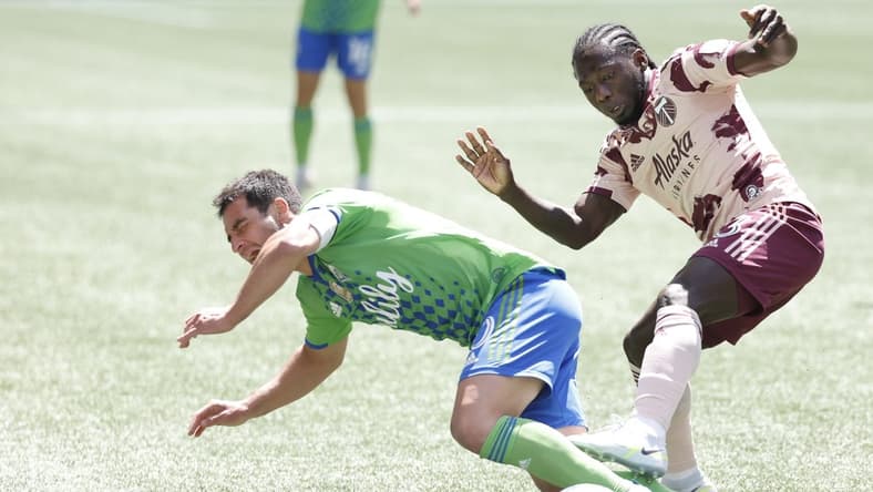 Jul 9, 2022; Seattle, Washington, USA; Seattle Sounders FC midfielder Nicolas Lodeiro (10) attempts to draw a foul against Portland Timbers forward Yimmi Chara (23) during the first half at Lumen Field. Mandatory Credit: Joe Nicholson-USA TODAY Sports