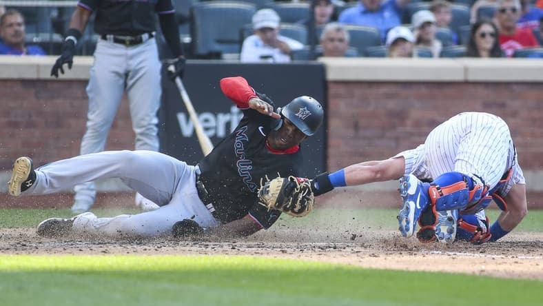 Jul 9, 2022; New York City, New York, USA; Miami Marlins center fielder Jesus Sanchez (7) is tagged out at home by New York Mets catcher James McCann (33) in the sixth inning at Citi Field. Mandatory Credit: Wendell Cruz-USA TODAY Sports
