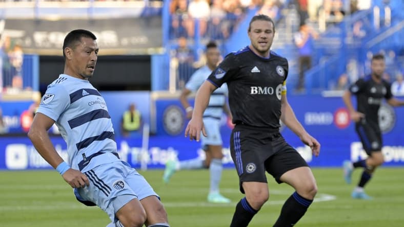 Jul 9, 2022; Montreal, Quebec, CAN; Sporting Kansas City midfielder Roger Espinoza (15) plays the ball and CF Montreal midfielder Samuel Piette (6) defends during the first half at Stade Saputo. Mandatory Credit: Eric Bolte-USA TODAY Sports