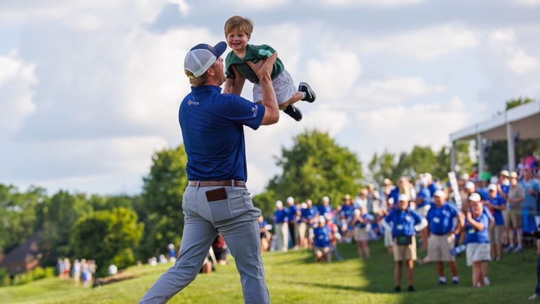 Jul 10, 2022; Nicholasville, Kentucky, USA; Trey Mullinax lifts up his two-year-old son Jude on the 18th green during the final round of the Barbasol Championship golf tournament. Mandatory Credit: Jordan Prather-USA TODAY Sports