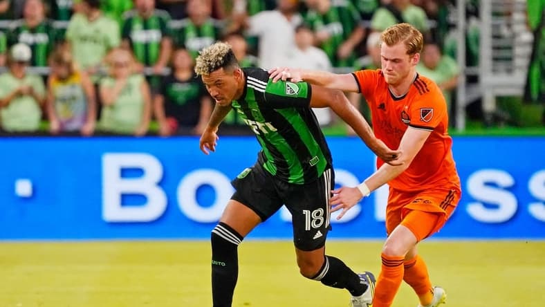 Jul 12, 2022; Austin, Texas, USA; Austin FC defender Julio Cascante (18) dribbles the ball against Houston Dynamo forward Thorleifur Ulfarsson (34) during the first half at Q2 Stadium. Mandatory Credit: Scott Wachter-USA TODAY Sports