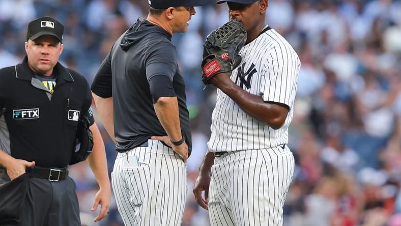 Jul 13, 2022; Bronx, New York, USA; New York Yankees manager Aaron Boone (17) talks with starting pitcher Luis Severino (40) during the second inning against the Cincinnati Reds at Yankee Stadium. Mandatory Credit: Vincent Carchietta-USA TODAY Sports