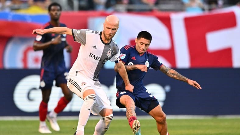 Jul 13, 2022; Chicago, Illinois, USA;  Toronto FC midfielder Michael Bradley (4) and Chicago Fire FC midfielder Federico Navarro (31) battle for control of the ball in the first half at Soldier Field. Mandatory Credit: Jamie Sabau-USA TODAY Sports