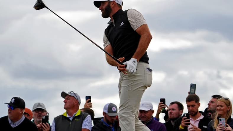 Jul 14, 2022; St. Andrews, SCT; Dustin Johnson takes a shot on the 14th hole during the first round of the 150th Open Championship golf tournament at St. Andrews Old Course. Mandatory Credit: Rob Schumacher-USA TODAY Sports
