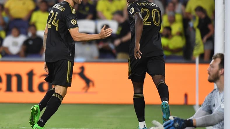 Jul 17, 2022; Nashville, Tennessee, USA; Los Angeles FC midfielder Ryan Hollingshead (24) and midfielder Daniel Crisostomo (20) celebrate after a goal past Nashville SC goalkeeper Joe Willis (1) during the second half at Geodis Park. Mandatory Credit: Christopher Hanewinckel-USA TODAY Sports