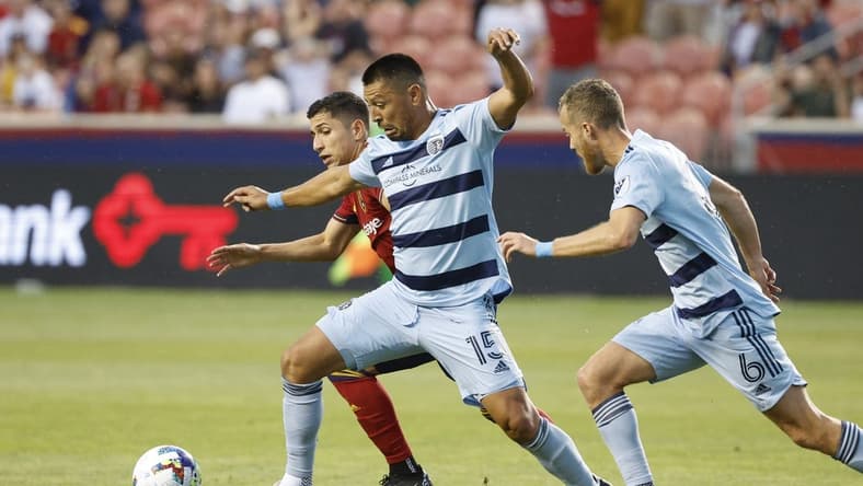 Jul 17, 2022; Sandy, Utah, USA; Sporting Kansas City midfielder Roger Espinoza (15) and midfielder Oriol Rosell (6) battle Real Salt Lake forward Jefferson Savarino (11) in the first half at Rio Tinto Stadium. Mandatory Credit: Jeffrey Swinger-USA TODAY Sports