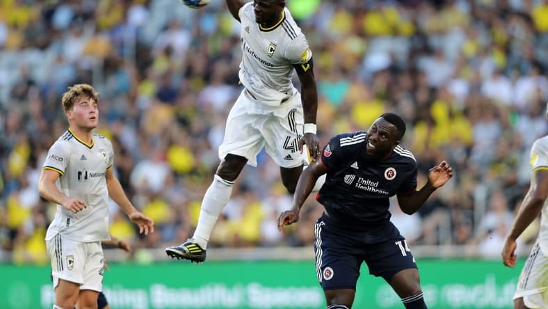 Jul 23, 2022; Columbus, Ohio, USA; Columbus Crew defender Jonathan Mensah (4) goes up for a header as New England Revolution forward Jozy Altidore (14) defends during the first half at Lower.com Field. Mandatory Credit: Joseph Maiorana-USA TODAY Sports
