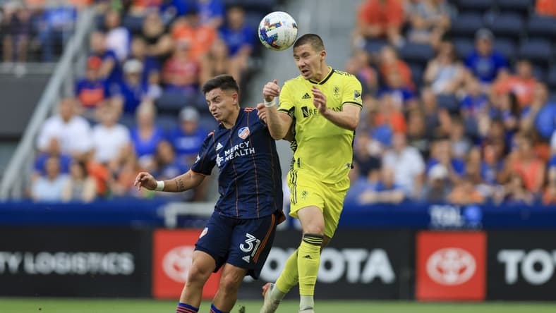 Jul 23, 2022; Cincinnati, Ohio, USA;  Nashville SC midfielder Alex Muyl (right) heads the ball against FC Cincinnati midfielder Alvaro Barreal (31) in the first half at TQL Stadium. Mandatory Credit: Aaron Doster-USA TODAY Sports