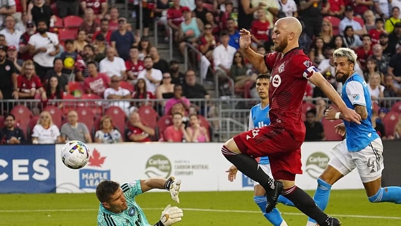 Jul 23, 2022; Toronto, Ontario, CAN; Toronto FC midfielder Michael Bradley (4) scores on Charlotte FC goalkeeper Kristijan Kahlina (1) during the first half at BMO Field. Mandatory Credit: John E. Sokolowski-USA TODAY Sports
