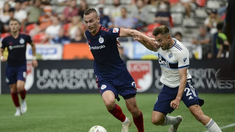 Jul 23, 2022; Vancouver, British Columbia, CAN; Vancouver Whitecaps FC defender Marcus Godinho (2) challenges Chicago Fire FC defender Boris Sekulic (2) during the first half at BC Place. Mandatory Credit: Anne-Marie Sorvin-USA TODAY Sports