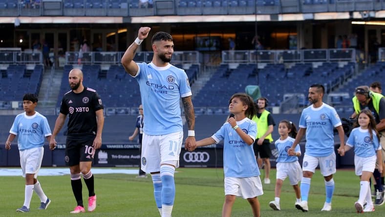 Jul 23, 2022; New York, New York, USA; New York City FC midfielder Valentin Castellanos (11) reacts as he is escorted onto the pitch by a young fan before a match against Inter Miami CF at Yankee Stadium. Mandatory Credit: Brad Penner-USA TODAY Sports