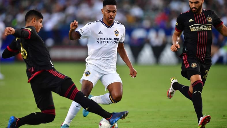 Jul 24, 2022; Carson, California, USA; Los Angeles Galaxy midfielder Rayan Raveloson (6) moves the ball against Atlanta United defender Alan Franco (6) and defender Juan Jose Purata (22) during the first half at Dignity Health Sports Park. Mandatory Credit: Gary A. Vasquez-USA TODAY Sports