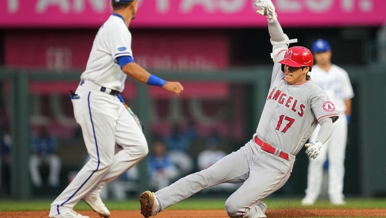 Jul 25, 2022; Kansas City, Missouri, USA; Los Angeles Angels designated hitter Shohei Ohtani (17) slides into second base for a double as Kansas City Royals shortstop Nicky Lopez (left) awaits the throw during the third inning at Kauffman Stadium. Mandatory Credit: Jay Biggerstaff-USA TODAY Sports