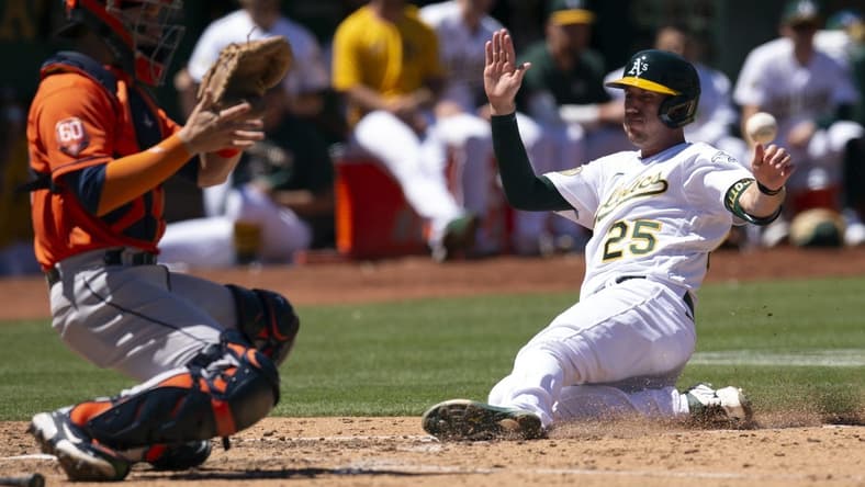 Jul 27, 2022; Oakland, California, USA; Oakland Athletics left fielder Stephen Piscotty (25) slides safely home ahead of the relay to Houston Astros catcher Korey Lee (38) on an RBI single by Skye Bolt during the seventh inning at RingCentral Coliseum. Mandatory Credit: D. Ross Cameron-USA TODAY Sports