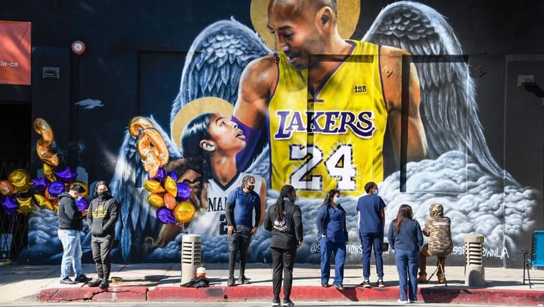 Jan 26, 2021; Los Angeles, California, USA; Fans gather at a mural of Kobe Bryant and his daughter Gianna painted on the wall of Hardcore Fitness Bootcamp gym in downtown Los Angeles. Bryant and his daughter and seven other persons died in a helicopter crash in Calabasas, Calif. on Jan. 26, 2020. Mandatory Credit: Robert Hanashiro-USA TODAY Sports