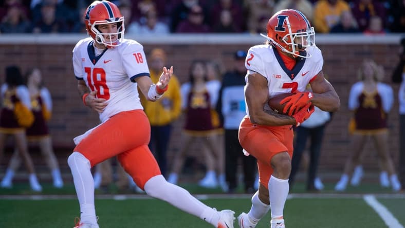 Nov 6, 2021; Minneapolis, Minnesota, USA; Illinois Fighting Illini quarterback Brandon Peters (18) passes the ball off to Illinois Fighting Illini running back Chase Brown (2) in the second quarter against the Minnesota Golden Gophers at Huntington Bank Stadium. Mandatory Credit: Matt Krohn-USA TODAY Sports
