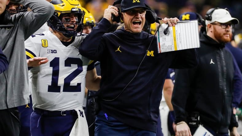 Michigan coach Jim Harbaugh and quarterback Cade McNamara celebrate a touchdown against Iowa during the first half of the Big Ten championship game at Lucas Oil Stadium in Indianapolis on Saturday, Dec. 4, 2021.

Syndication Detroit Free Press