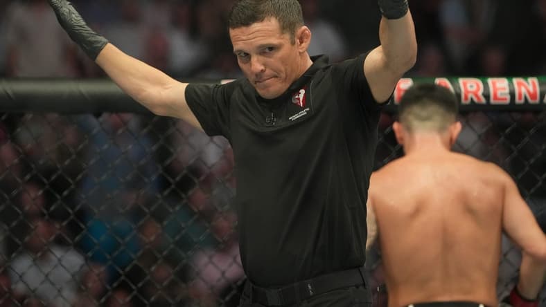Jul 2, 2022; Las Vegas, Nevada, USA; Ring referee Jason Herzog waves off the fight after Pedro Munhoz (red gloves) was accidentally poked in the eye during the bout against Sean O'Malley (blue gloves) during UFC 276 at T-Mobile Arena. Mandatory Credit: Stephen R. Sylvanie-USA TODAY Sports