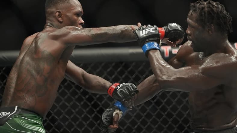 Jul 2, 2022; Las Vegas, Nevada, USA; Israel Adesanya (red gloves) and Jared Cannonier (blue gloves) fight in a bout during UFC 276 at T-Mobile Arena. Mandatory Credit: Stephen R. Sylvanie-USA TODAY Sports