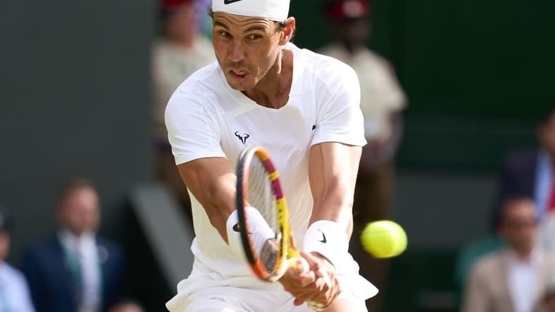 Jul 6, 2022; London, England, United Kingdom; Rafael Nadal (ESP) returns a shot during his quarter finals men   s singles match against Taylor Fritz (USA) on Centre court at All England Lawn Tennis and Croquet Club. Mandatory Credit: Peter van den Berg-USA TODAY Sports