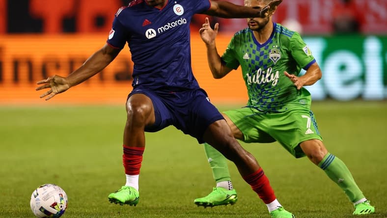 Jul 16, 2022; Chicago, Illinois, USA; Chicago Fire forward Chinonso Offor (9) kicks the ball around Seattle Sounders midfielder Cristian Roldan (7) during the second half at Soldier Field. Mandatory Credit: Mike Dinovo-USA TODAY Sports