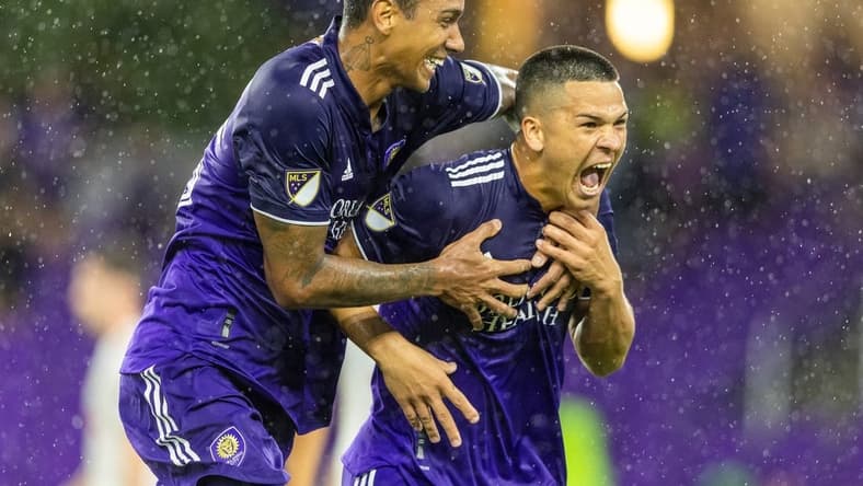 Jul 27, 2022; Orlando, Florida, US;   Orlando City midfielder Cesar Araujo (5) is congratulated by defender Antonio Carlos (25) after scoring his second goal of the match against the New York Red Bulls in the second half during the US Open Cup semifinals at Exploria Stadium. Mandatory Credit: Nathan Ray Seebeck-USA TODAY Sports
