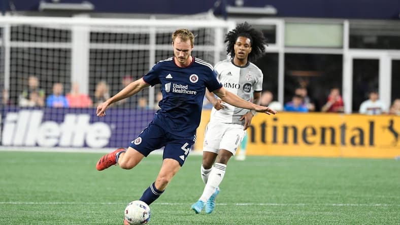Jul 30, 2022; Foxborough, MA, USA; New England Revolution defender Henry Kessler (4) controls the ball in front of Toronto FC forward Jayden Nelson (11) during the first half at Gillette Stadium. Mandatory Credit: Eric Canha-USA TODAY Sports