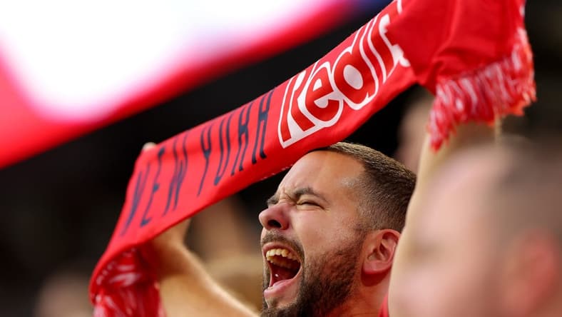 Aug 2, 2022; Harrison, New Jersey, USA; A New York Red Bulls fan holds a scarf and cheers during the national anthem before the game between the Red Bulls and the Colorado Rapids at Red Bull Arena. Mandatory Credit: Vincent Carchietta-USA TODAY Sports