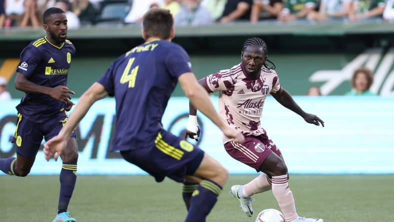 Aug 3, 2022; Portland, Oregon, USA; Portland Timbers forward Yimmi Chara (23) looks to passes the ball against Nashville SC defender Dave Romney (4) during the first half at Providence Park. Mandatory Credit: Jaime Valdez-USA TODAY Sports