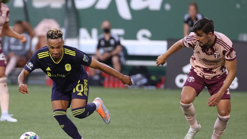Aug 3, 2022; Portland, Oregon, USA;  Nashville SC midfielder Hany Mukhtar (10) dribbles around Portland Timbers defender Jose van Rankin (2) during the first half at Providence Park. Mandatory Credit: Jaime Valdez-USA TODAY Sports