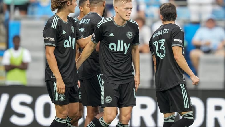 Aug 3, 2022; Charlotte, North Carolina, USA; Charlotte FC forward Karol Swiderski (11) gets congratulations on his first goal against the D.C. United from his teammates during the first half at Bank of America Stadium. Mandatory Credit: Jim Dedmon-USA TODAY Sports