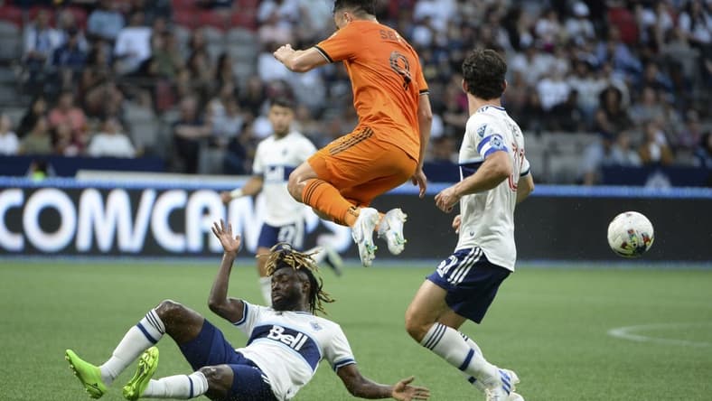 Aug 5, 2022; Vancouver, British Columbia, CAN; Houston Dynamo FC forward Sebastian Ferreira (9) jumps over Vancouver Whitecaps FC midfielder Leonard Owusu (17) during the first half at BC Place. Mandatory Credit: Anne-Marie Sorvin-USA TODAY Sports