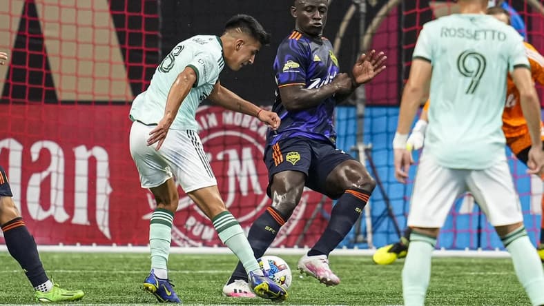 Aug 6, 2022; Atlanta, Georgia, USA; Atlanta United midfielder Thiago Almada (8) takes a shot against Seattle Sounders defender Yeimar Gomez (28) during the first half at Mercedes-Benz Stadium. Mandatory Credit: Dale Zanine-USA TODAY Sports