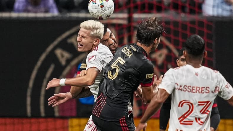 Aug 17, 2022; Atlanta, Georgia, USA; Atlanta United defender Juan Jose Purata (22) and New York Red Bulls forward Patryk Klimala (9) go for the ball during the first half at Mercedes-Benz Stadium. Mandatory Credit: Dale Zanine-USA TODAY Sports