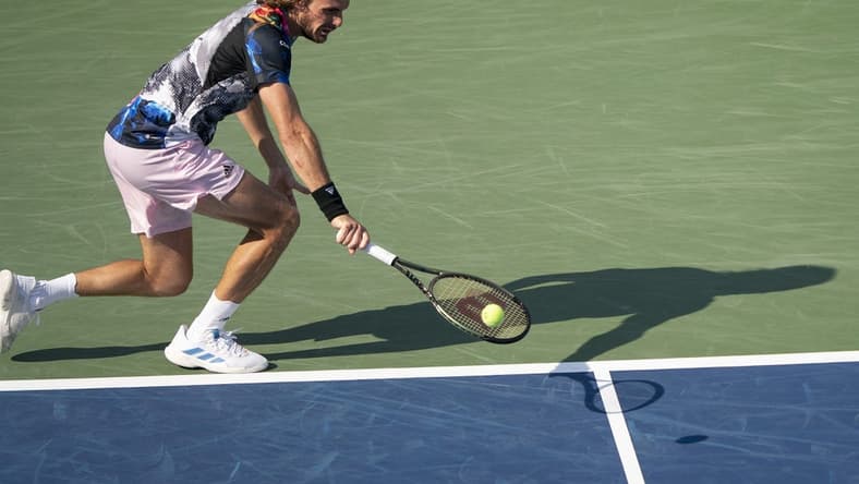 Aug 19, 2022; Cincinnati, OH, USA; Stefanos Tsitsipas (GRE) returns a shot during his match against John Isner (USA) at the Western & Southern Open at the Lindner Family Tennis Center. Mandatory Credit: Susan Mullane-USA TODAY Sports