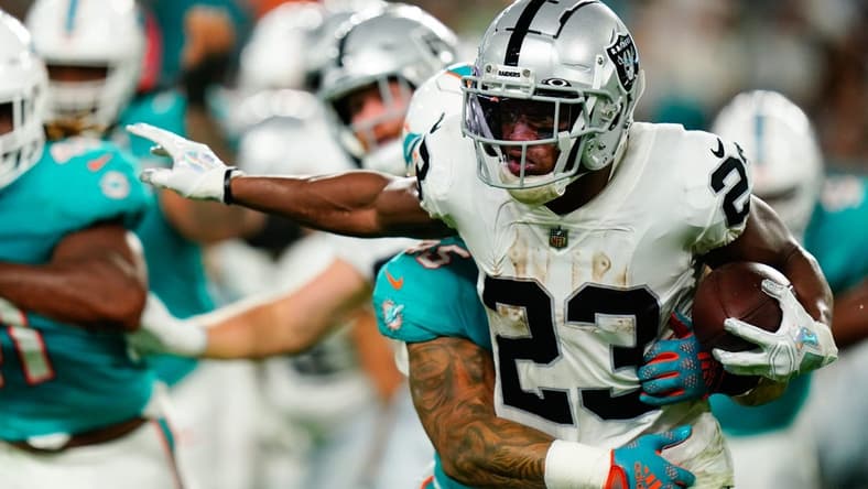 Aug 20, 2022; Miami Gardens, Florida, USA; Las Vegas Raiders running back Kenyan Drake (23) runs against the Miami Dolphins during the second quarter at Hard Rock Stadium. Mandatory Credit: Rich Storry-USA TODAY Sports