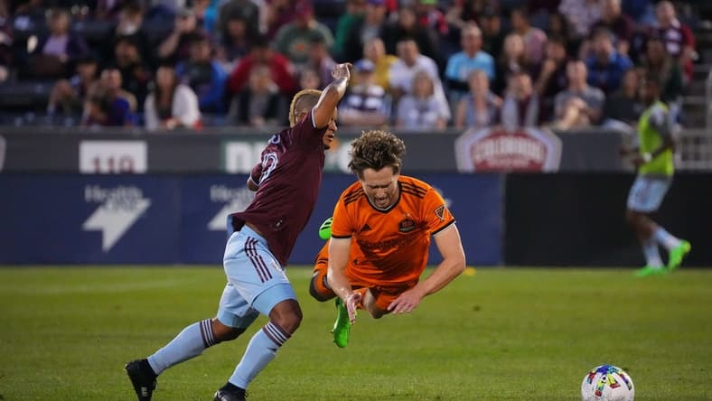 Aug 20, 2022; Commerce City, Colorado, USA; Houston Dynamo FC defender Adam Lundqvist (3) falls in front of Colorado Rapids forward Michael Barrios (12) in the first half at Dick's Sporting Goods Park. Mandatory Credit: Ron Chenoy-USA TODAY Sports