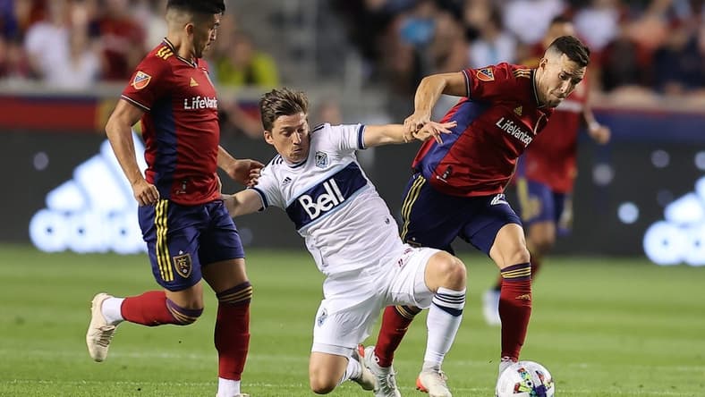 Aug 20, 2022; Sandy, Utah, USA; Vancouver Whitecaps FC midfielder Ryan Gauld (25) fights for a ball against Real Salt Lake defender Aaron Herrera (22) in the first half at Rio Tinto Stadium. Mandatory Credit: Rob Gray-USA TODAY Sports