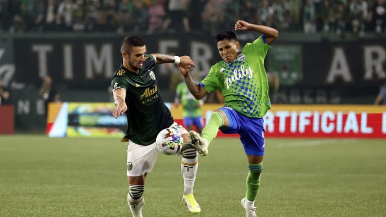 Aug 26, 2022; Portland, Oregon, USA; Portland Timbers defender Dario Zuparic (13, left) battles for the ball with Seattle Sounders forward Raul Ruidiaz (9) during the first half at Providence Park. Mandatory Credit: Soobum Im-USA TODAY Sports