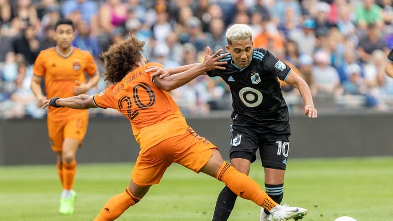 Aug 27, 2022; Saint Paul, Minnesota, USA; Minnesota United midfielder Emanuel Reynoso (10) evades the defense of Houston Dynamo midfielder Adalberto Carrasquilla (20) in the first half at Allianz Field. Mandatory Credit: Matt Blewett-USA TODAY Sports