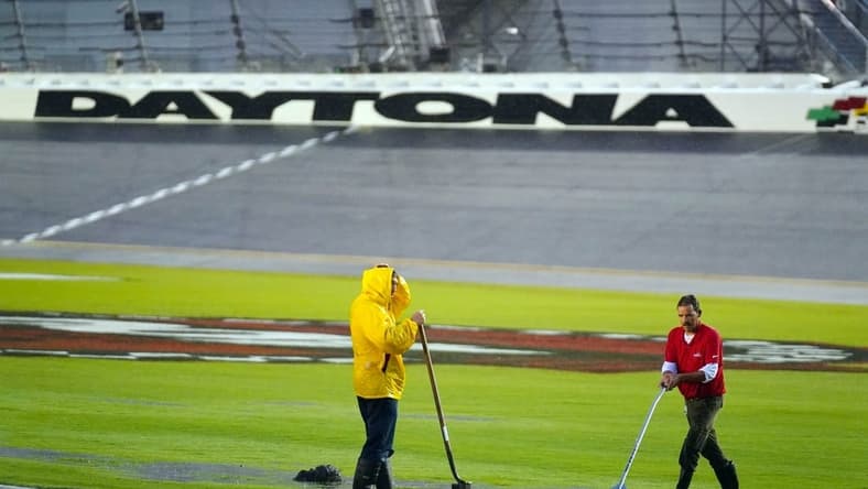 Aug 27, 2022; Daytona Beach, Florida, USA; Grounds crews work to mediate pooling water in the infield trioval during a rain delay for the Coke Zero Sugar 400 at Daytona International Speedway. Mandatory Credit: John David Mercer-USA TODAY Sports