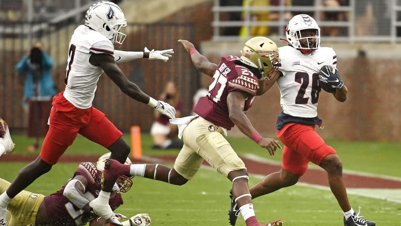 Aug 27, 2022; Tallahassee, Florida, USA; Duquesne Dukes running back Demarcus Ware (28) runs the ball past Florida State Seminoles defensive back Akeem Dent Sr. (27) during the first half at Doak S. Campbell Stadium. Mandatory Credit: Melina Myers-USA TODAY Sports