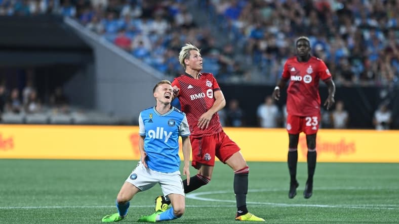 Aug 27, 2022; Charlotte, North Carolina, USA; Charlotte FC attacker Karol Swiderski (11) collides with Toronto FC defender Lukas MacNaughton (5) in the first half at Bank of America Stadium. Mandatory Credit: Griffin Zetterberg-USA TODAY Sports