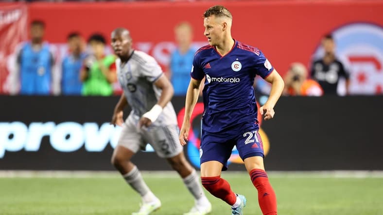 Aug 27, 2022; Chicago, Illinois, USA; Chicago Fire midfielder Fabian Herbers (21) kicks the ball past CF Montreal defender Kamal Miller (3) during the second half at Soldier Field. Mandatory Credit: Mike Dinovo-USA TODAY Sports