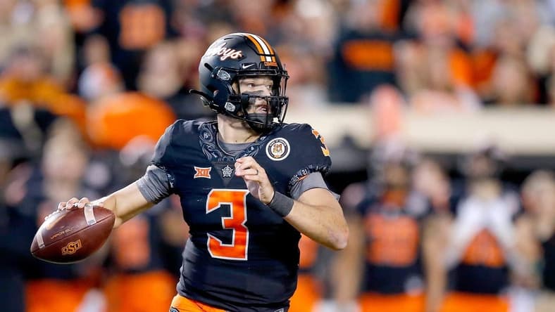 OSU quarterback Spencer Sanders looks to make a pass during a 37-33 win against OU last season.

cover