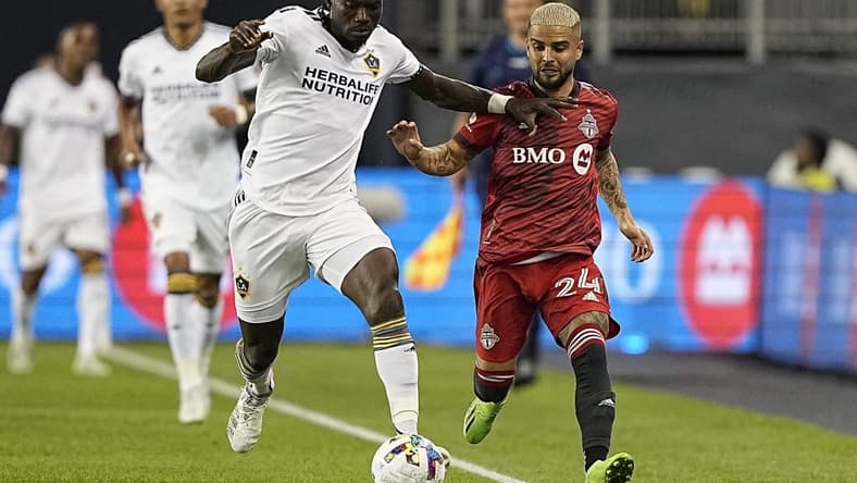 Aug 31, 2022; Toronto, Ontario, CAN; LA Galaxy defender Sega Coulibaly (4) battles for the ball with Toronto FC midfielder Lorenzo Insigne (24) during the first half at BMO Field. Mandatory Credit: John E. Sokolowski-USA TODAY Sports