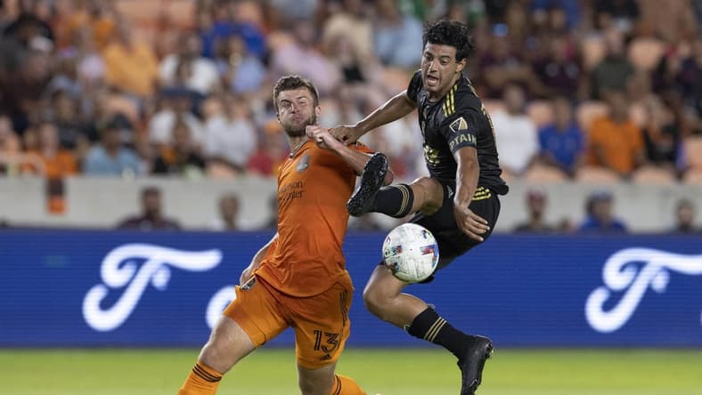Aug 31, 2022; Houston, Texas, USA; Los Angeles FC forward Carlos Vela (10) traps the ball in mid air against Houston Dynamo FC defender Ethan Bartlow (13) in the first half at PNC Stadium. Mandatory Credit: Thomas Shea-USA TODAY Sports
