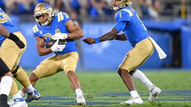 Nov 13, 2021; Pasadena, California, USA; UCLA Bruins quarterback Dorian Thompson-Robinson (1) hands the ball off to running back Zach Charbonnet (24) the first half against the Colorado Buffaloes at Rose Bowl. Mandatory Credit: Jayne Kamin-Oncea-USA TODAY Sports