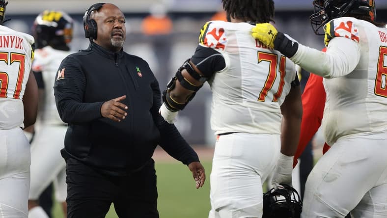 Dec 29, 2021; New York, NY, USA; Maryland Terrapins head coach Mike Locksley (left) talks with offensive lineman Jaelyn Duncan (71) during the second half of the 2021 Pinstripe Bowl against the Virginia Tech Hokies at Yankee Stadium. Mandatory Credit: Vincent Carchietta-USA TODAY Sports